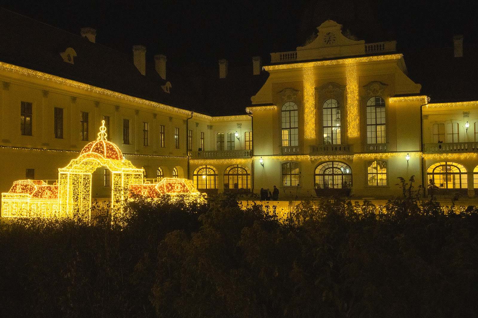 Beleuchtetes Schloss und goldener Lichtpavillon bei Nacht