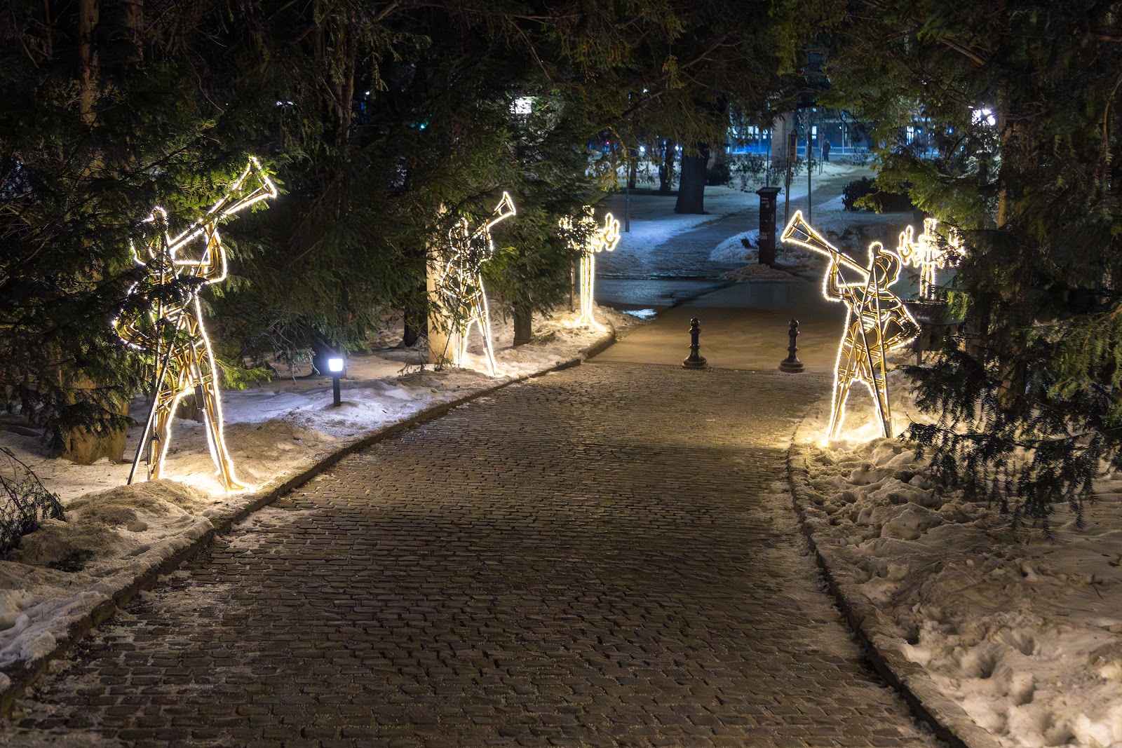 Beleuchteter Rundweg mit leuchtenden Trompetenfiguren